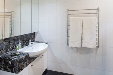 Photo of a modern bathroom in Melbourne with a double shower, black and white tile, ceramic tile, white walls, porcelain floors and granite benchtops.
