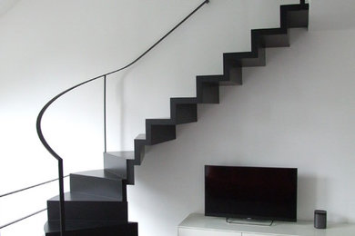 Gewendelte, Kleine Moderne Holztreppe mit Stahlgeländer und Holz-Setzstufen in Dortmund