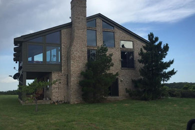 Inspiration for a large transitional brown two-story brick gable roof remodel in Austin