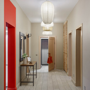 Inspiration för mellanstora eklektiska ingångspartier, med klinkergolv i keramik, en enkeldörr, mellanmörk trädörr, grått golv och beige väggar