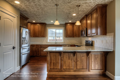 Inspiration for an u-shaped brown floor eat-in kitchen remodel in Portland with an undermount sink, raised-panel cabinets, medium tone wood cabinets, granite countertops, white backsplash, subway tile backsplash, stainless steel appliances, a peninsula and multicolored countertops