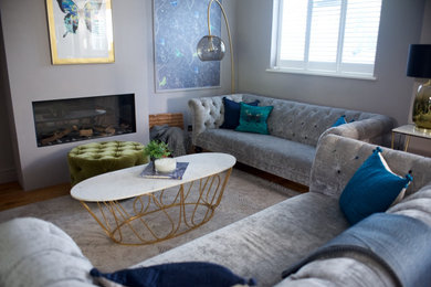 Inspiration for a large modern formal and enclosed medium tone wood floor living room remodel in London with gray walls, a wood stove, a plaster fireplace and a wall-mounted tv