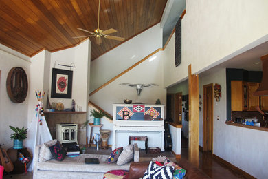 Large southwest formal and enclosed concrete floor and brown floor living room photo in Denver with beige walls, a wood stove, a metal fireplace and no tv