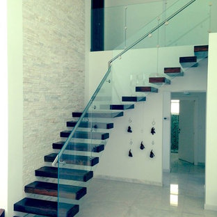 Expansive traditional wood l-shaped staircase in Miami with glass risers.