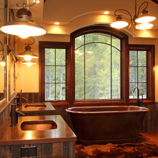 Example of a large mountain style master medium tone wood floor freestanding bathtub design in Denver with an undermount sink, medium tone wood cabinets, beige walls, shaker cabinets and copper countertops