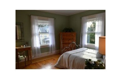 他の地域にある広いミッドセンチュリースタイルのおしゃれな客用寝室 (緑の壁、無垢フローリング) のレイアウト