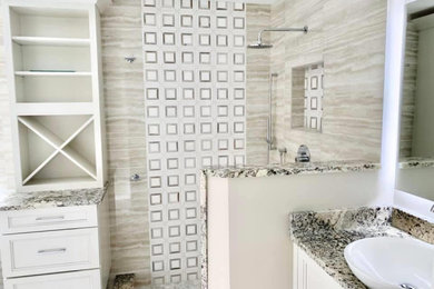 Inspiration for a mid-sized modern master bathroom in Miami with a corner shower, beige tile, porcelain floors, granite benchtops and a built-in vanity.