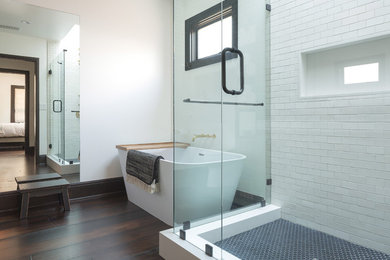 Transitional wet room bathroom in Los Angeles with a freestanding tub, white tile, subway tile, white walls, dark hardwood floors, a hinged shower door and brown floor.