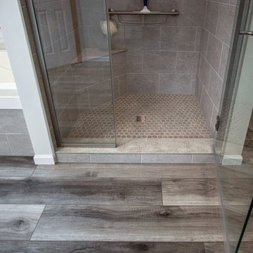 Waypoint Gray Shaker Door Cabinetry with Tiled Shower and Matching Tub Surround
