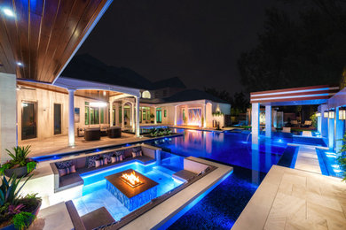 Inspiration for a large contemporary backyard tile and custom-shaped infinity and privacy pool remodel in Tampa