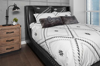 Example of a mid-sized trendy guest dark wood floor and brown floor bedroom design in Orange County with gray walls
