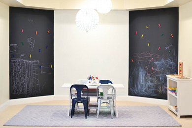 Photo of a mid-sized modern gender-neutral kids' playroom for kids 4-10 years old in New York with white walls and carpet.