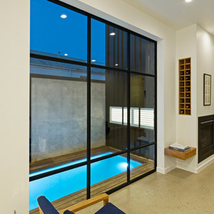 Modern inredning av en liten rektangulär pool längs med huset, med trädäck