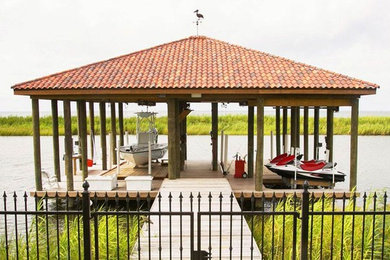 Design ideas for a large traditional backyard deck in New Orleans with with dock.