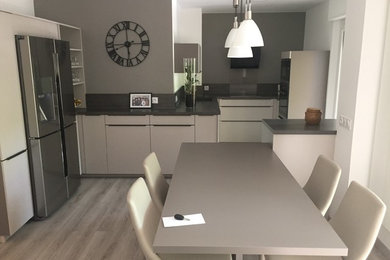 Cette photo montre une très grande cuisine ouverte moderne avec un plan de travail en bois et îlot.