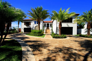 Huge mediterranean white three-story stucco house exterior idea in Tampa with a hip roof and a tile roof