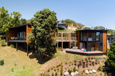 Diseño de fachada de casa negra moderna de dos plantas con revestimiento de madera y tejado de metal