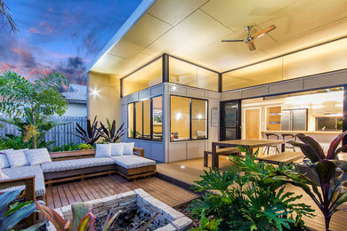 Small contemporary backyard deck in Brisbane with a fire feature and no cover.