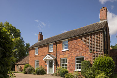 This is an example of a medium sized and red classic two floor brick and side house exterior in Cambridgeshire with a tiled roof and a red roof.
