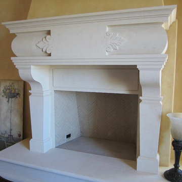 Mediterranean hand-carved stone fireplace with a raised hearth.