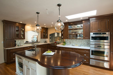 Kitchen - contemporary light wood floor kitchen idea in Other with an undermount sink, recessed-panel cabinets, dark wood cabinets, ceramic backsplash, stainless steel appliances and an island