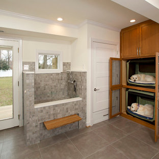 Cette image montre une buanderie traditionnelle en L multi-usage et de taille moyenne avec un sol en carrelage de porcelaine, un placard à porte shaker, des portes de placard en bois brun et un mur blanc.