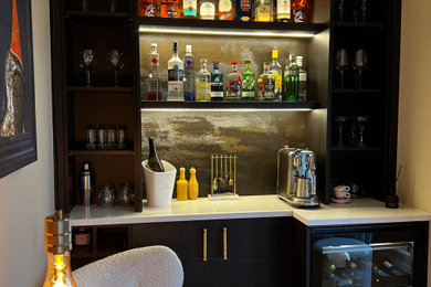 Example of a small minimalist l-shaped wet bar design in Other with dark wood cabinets, quartzite countertops, multicolored backsplash, quartz backsplash and white countertops