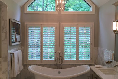Example of a large trendy master gray tile, white tile and marble tile marble floor and gray floor freestanding bathtub design in Atlanta with gray cabinets, gray walls, an undermount sink, quartz countertops and white countertops
