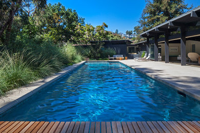 Inspiration for a large modern backyard rectangular lap pool in Los Angeles with concrete slab.
