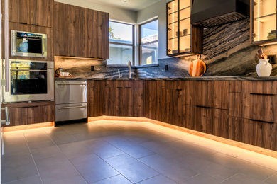 Eat-in kitchen - large modern l-shaped porcelain tile and gray floor eat-in kitchen idea in Phoenix with a single-bowl sink, flat-panel cabinets, medium tone wood cabinets, quartzite countertops, brown backsplash, stone slab backsplash, stainless steel appliances, an island and brown countertops