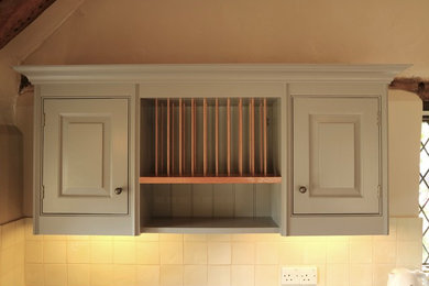 Aménagement d'une cuisine américaine campagne en U de taille moyenne avec un placard avec porte à panneau surélevé, des portes de placard grises et un plan de travail en granite.