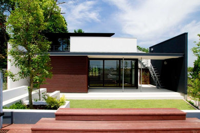 Large asian two-storey brown house exterior in Other with wood siding, a shed roof and a metal roof.