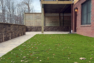 Inspiration for a mid-sized full sun backyard concrete paver and wood fence retaining wall landscape.