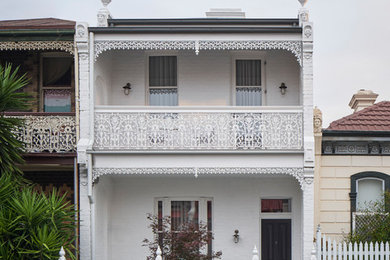 Mid-sized victorian three-storey brick white house exterior in Melbourne with a gable roof and a mixed roof.