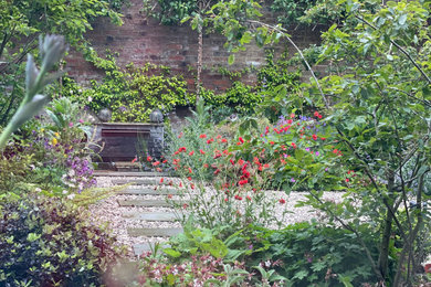 Small bohemian courtyard full sun garden in Kent with an outdoor games court and natural stone paving.