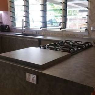 Mid-sized eclectic kitchen pantry remodeling - Mid-sized eclectic u-shaped slate floor kitchen pantry photo in Darwin with a drop-in sink, flat-panel cabinets, blue cabinets, solid surface countertops, gray backsplash, mosaic tile backsplash, stainless steel appliances and two islands