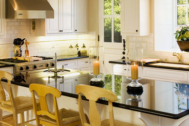 Mid-sized transitional u-shaped medium tone wood floor and brown floor open concept kitchen photo in San Diego with white backsplash, subway tile backsplash, stainless steel appliances, an undermount sink, raised-panel cabinets, white cabinets, quartzite countertops and an island