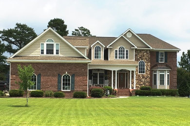 Inspiration for a large timeless beige two-story mixed siding exterior home remodel in Other with a shingle roof