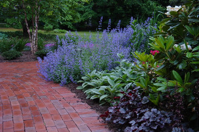 This is an example of a mid-sized traditional partial sun backyard brick landscaping in Bridgeport.