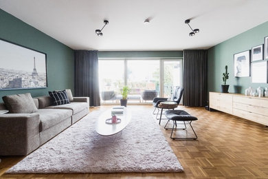 Inspiration for a mid-sized contemporary enclosed family room in Frankfurt with green walls, medium hardwood floors and brown floor.