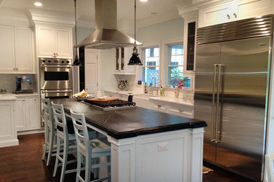 Example of a trendy single-wall brown floor kitchen design in New York with beaded inset cabinets, an island and white countertops