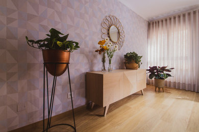 Diseño de salón cerrado tradicional renovado sin chimenea con paredes blancas, suelo laminado, pared multimedia, suelo marrón y papel pintado