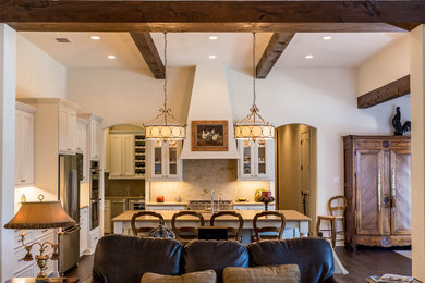 Inspiration for a mid-sized timeless l-shaped dark wood floor open concept kitchen remodel in Austin with a single-bowl sink, glass-front cabinets, white cabinets, granite countertops, beige backsplash, stone slab backsplash, stainless steel appliances and an island