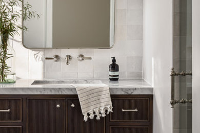 Mid-sized elegant master white tile and porcelain tile porcelain tile, black floor and single-sink alcove shower photo in San Diego with beaded inset cabinets, dark wood cabinets, a two-piece toilet, white walls, an undermount sink, marble countertops, a hinged shower door, white countertops, a niche and a built-in vanity
