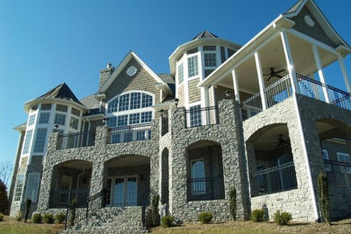 Inspiration for a large beige two-story stone exterior home remodel in Other