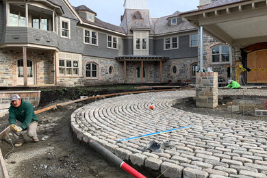 Design ideas for a large country front yard full sun driveway for summer in New York with with path and natural stone pavers.