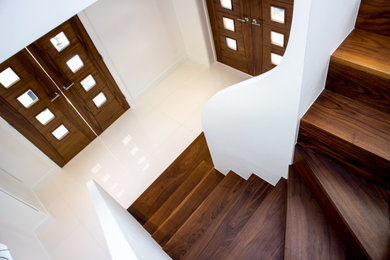 Ejemplo de escalera en L contemporánea de tamaño medio con escalones de madera y contrahuellas de madera