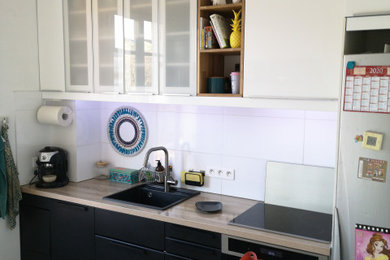Inspiration pour une cuisine parallèle et encastrable minimaliste fermée et de taille moyenne avec un évier 1 bac, un placard à porte vitrée, des portes de placard noires, un plan de travail en stratifié, une crédence blanche, une crédence en céramique, carreaux de ciment au sol, aucun îlot, un sol gris et un plan de travail beige.