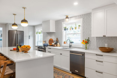 Inspiration for a mid-sized transitional galley porcelain tile and brown floor eat-in kitchen remodel in Portland Maine with an undermount sink, shaker cabinets, white cabinets, quartz countertops, blue backsplash, porcelain backsplash, stainless steel appliances, an island and white countertops