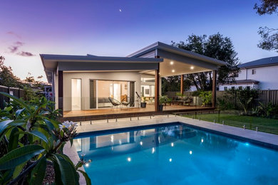 This is an example of a large contemporary one-storey concrete grey house exterior in Gold Coast - Tweed with a flat roof and a metal roof.